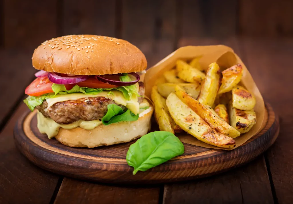 Healthy hamburger with fresh vegetables and sweet potato fries.