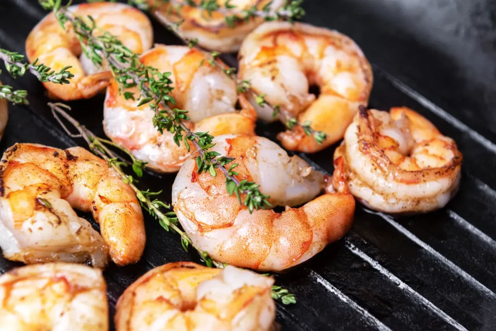 Platter of perfectly grilled shrimp skewers with garnishes