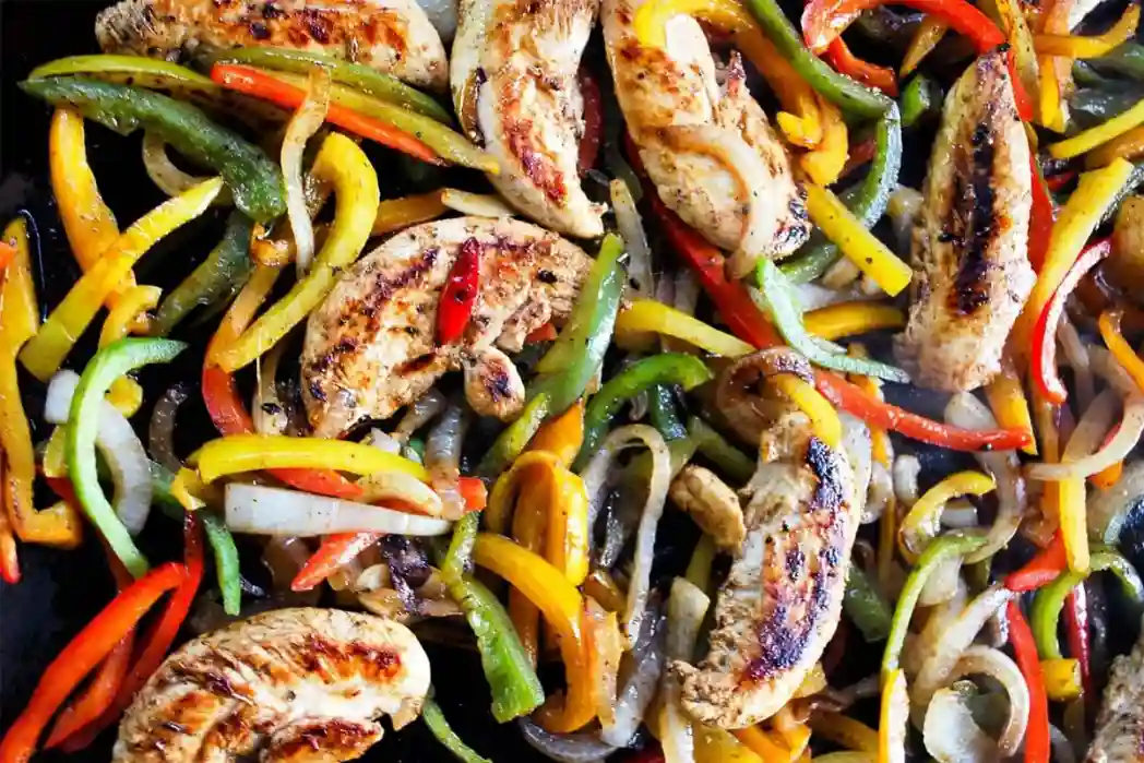 Juicy grilled chicken and fresh vegetables prepared on a Blackstone griddle.