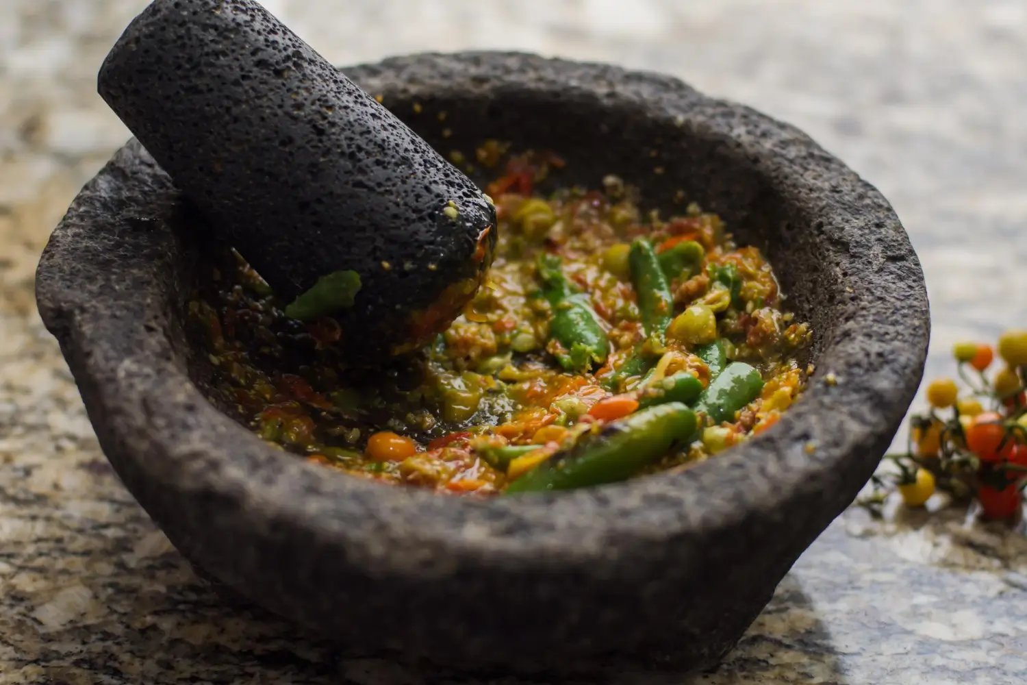 Authentic molcajete filled with fresh salsa on a rustic table.