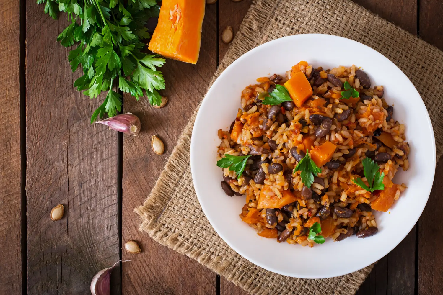 Red rice served in a bowl with fresh herbs and vegetables.