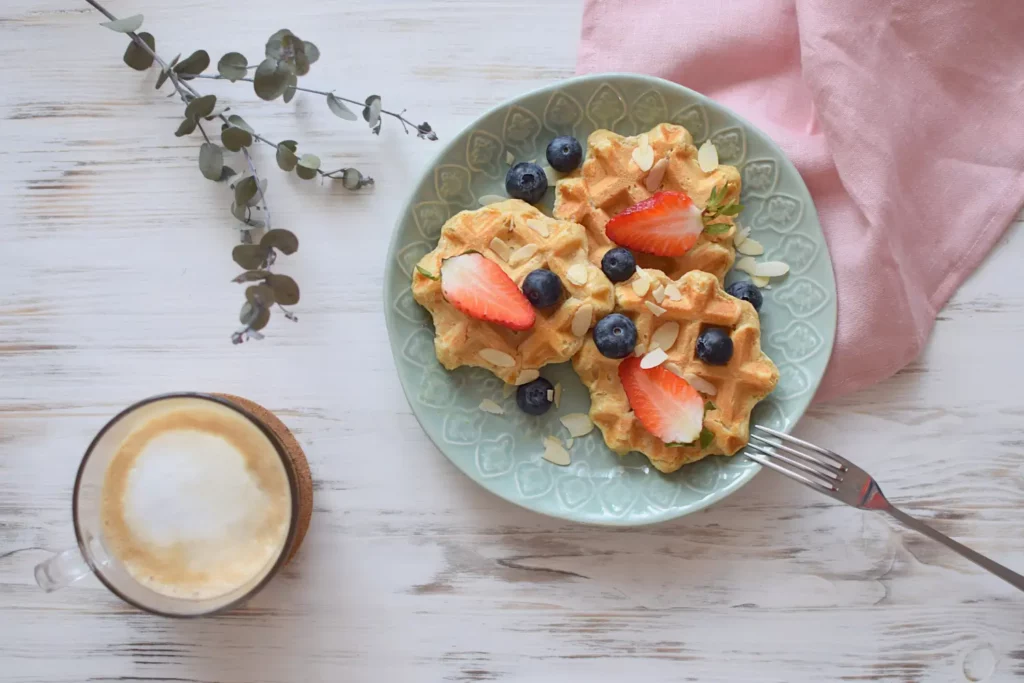 Golden Bisquick waffles topped with butter, fresh berries, and syrup