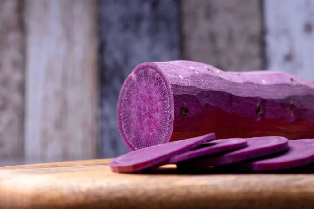 Whole and sliced purple sweet potatoes with and without peel.