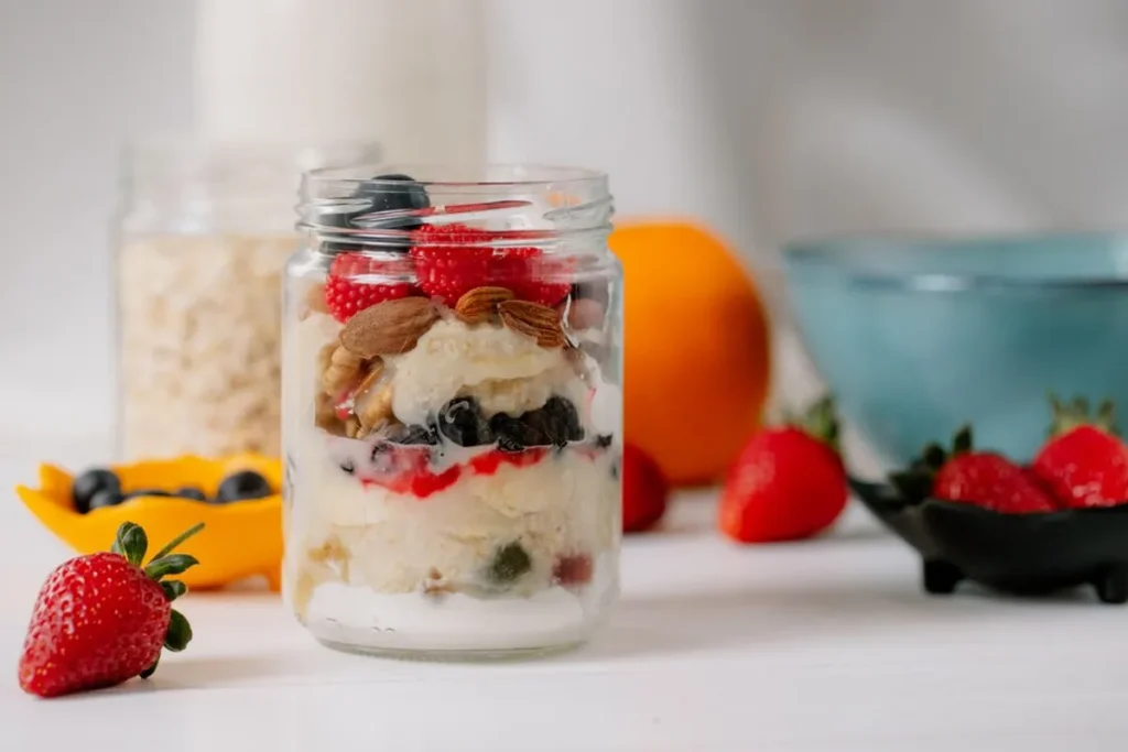 A no-bake cheesecake layered in a jar with graham cracker crumbs, creamy filling, and fruit compote