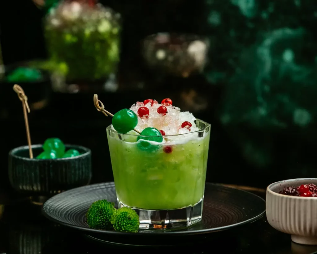 Bright green Grinch Punch bowl with holiday decorations