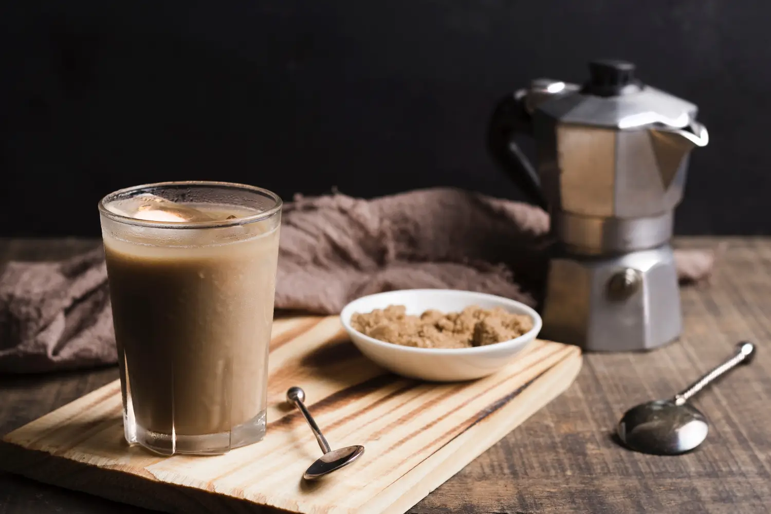 Iced protein coffee with caramel drizzle and cocoa powder on a countertop.