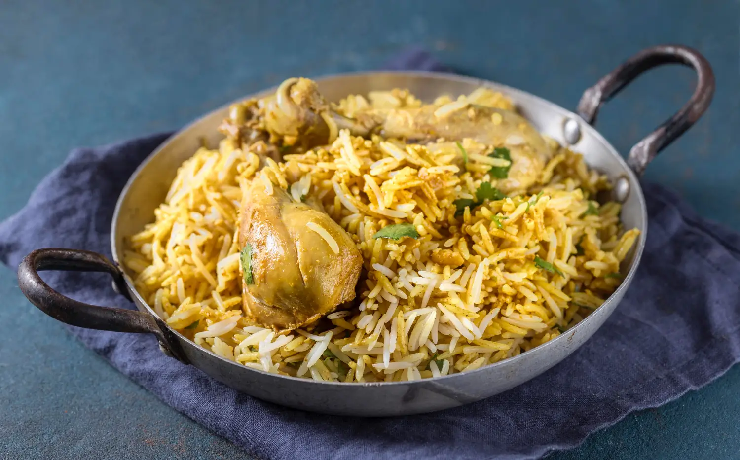 Chicken and yellow rice served with herbs and lemon