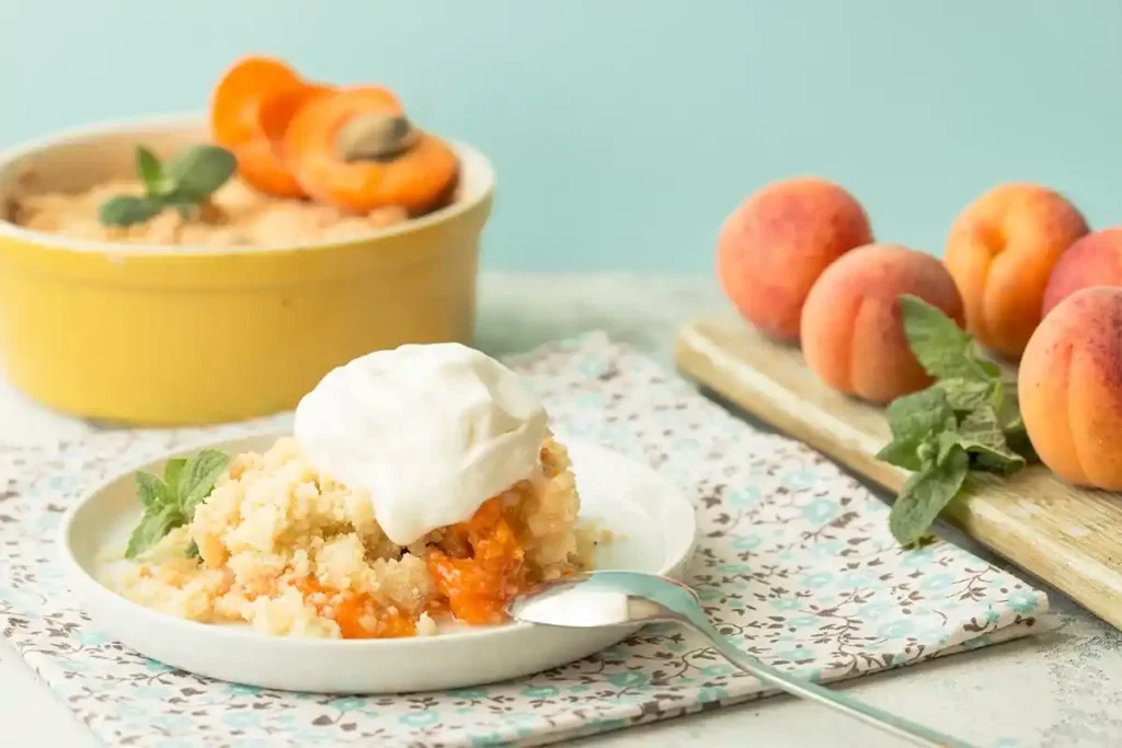 Slice of peach cobbler with cake mix and vanilla ice cream