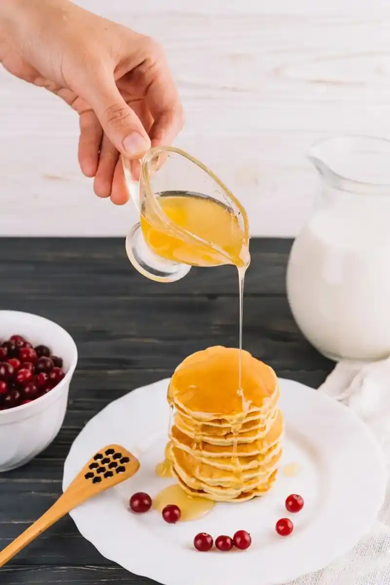 A cocktail with honey simple syrup being poured in