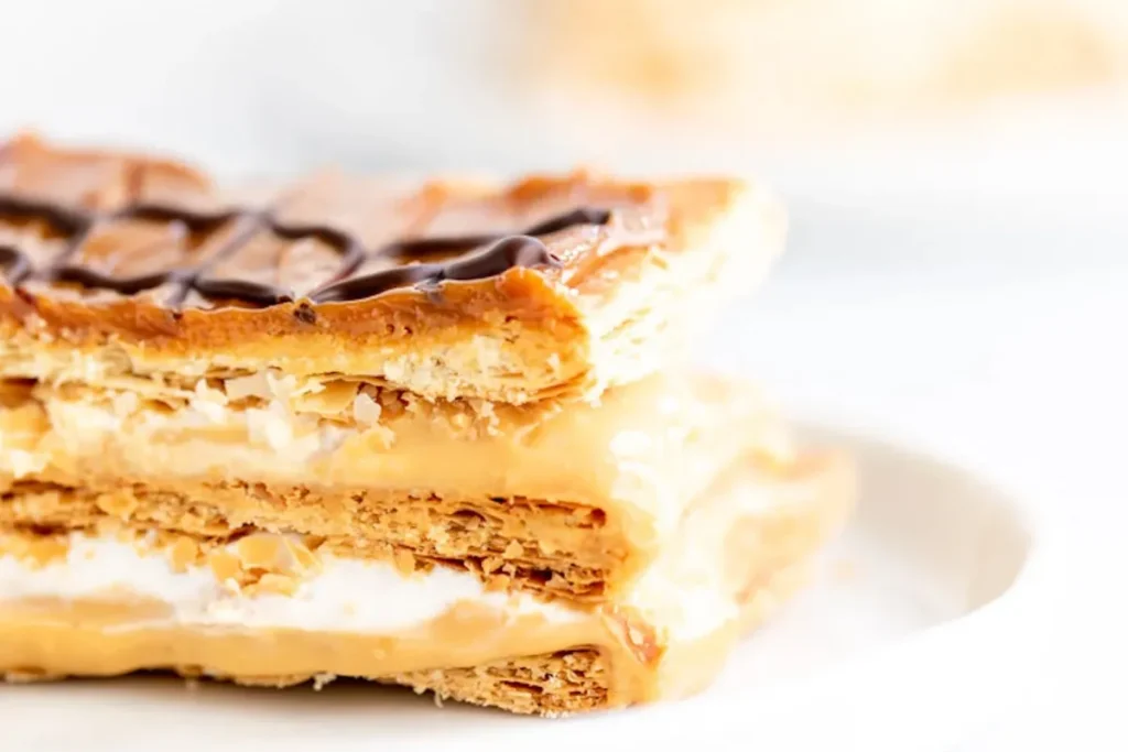 A layered mille-feuille with flaky puff pastry and creamy custard, topped with powdered sugar