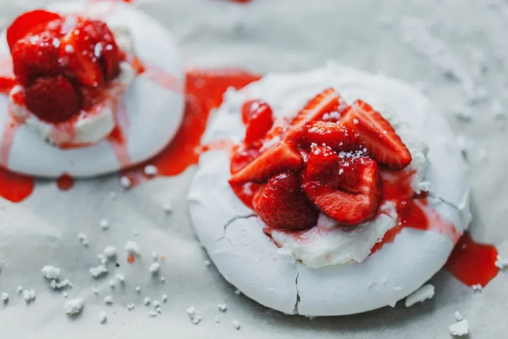 A pavlova with a crisp meringue shell, topped with whipped cream and fresh fruit