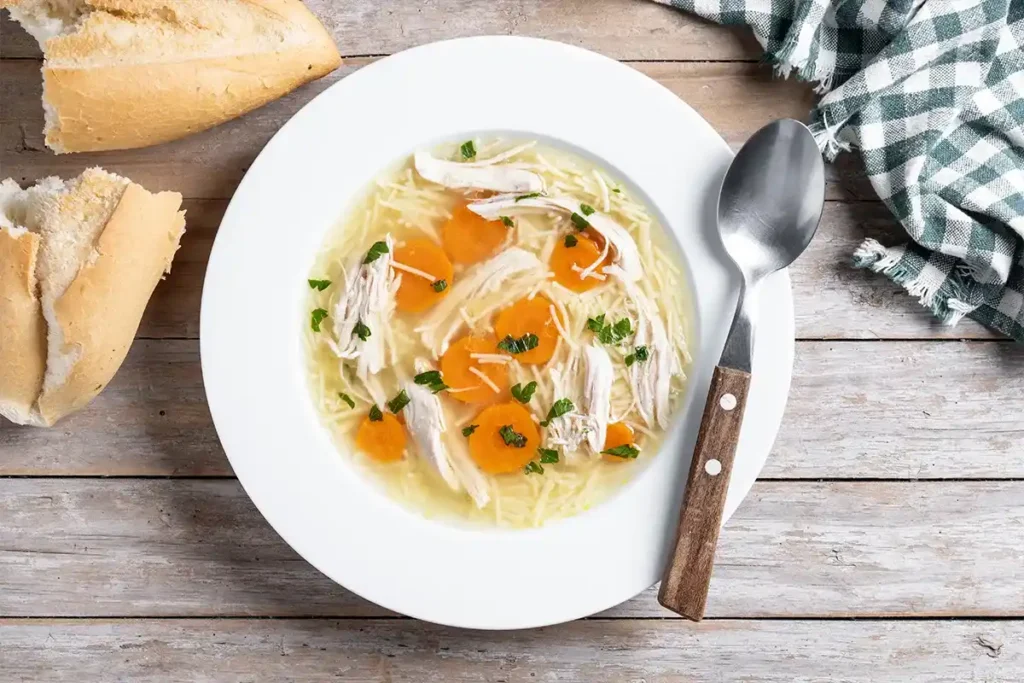 A bowl of classic chicken noodle soup with shredded rotisserie chicken, carrots, celery, and egg noodles