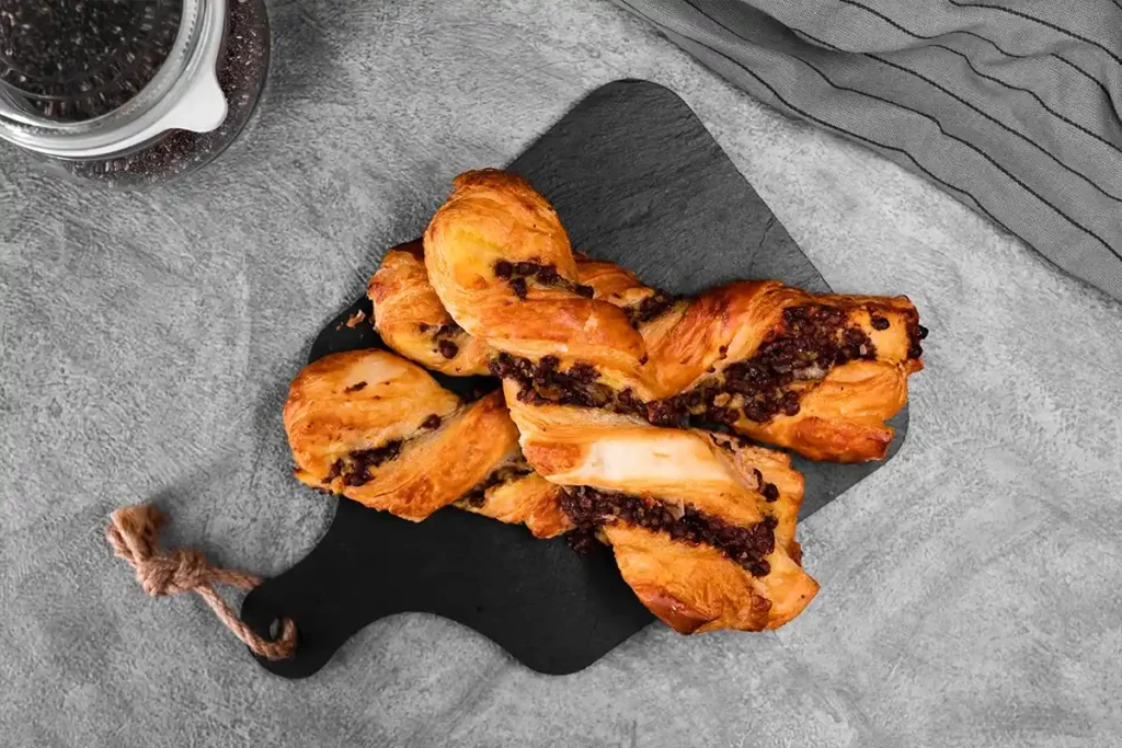 Chocolate puff pastry twists with hazelnut-chocolate spread and powdered sugar