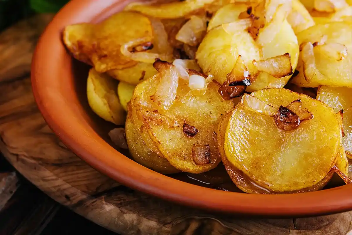 Crispy and tender smothered potatoes served on a plate