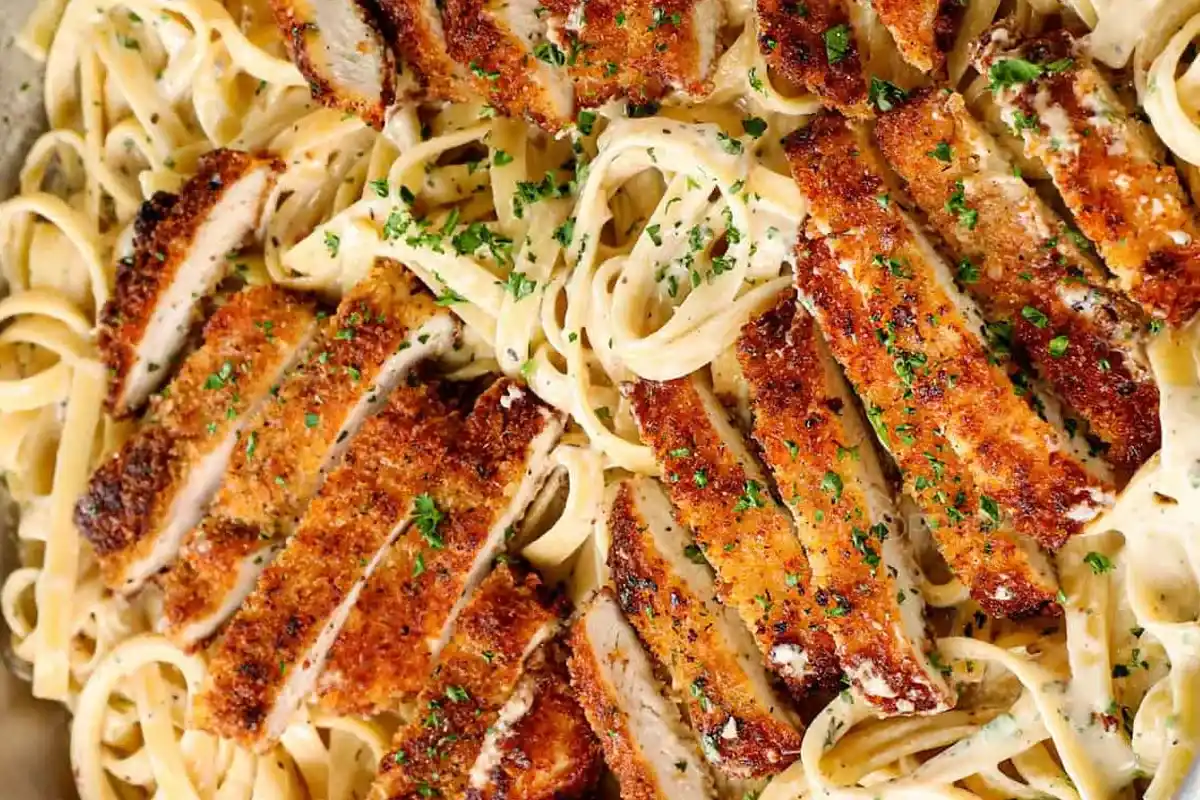 Overhead shot of crispy breaded chicken with fettuccine Alfredo