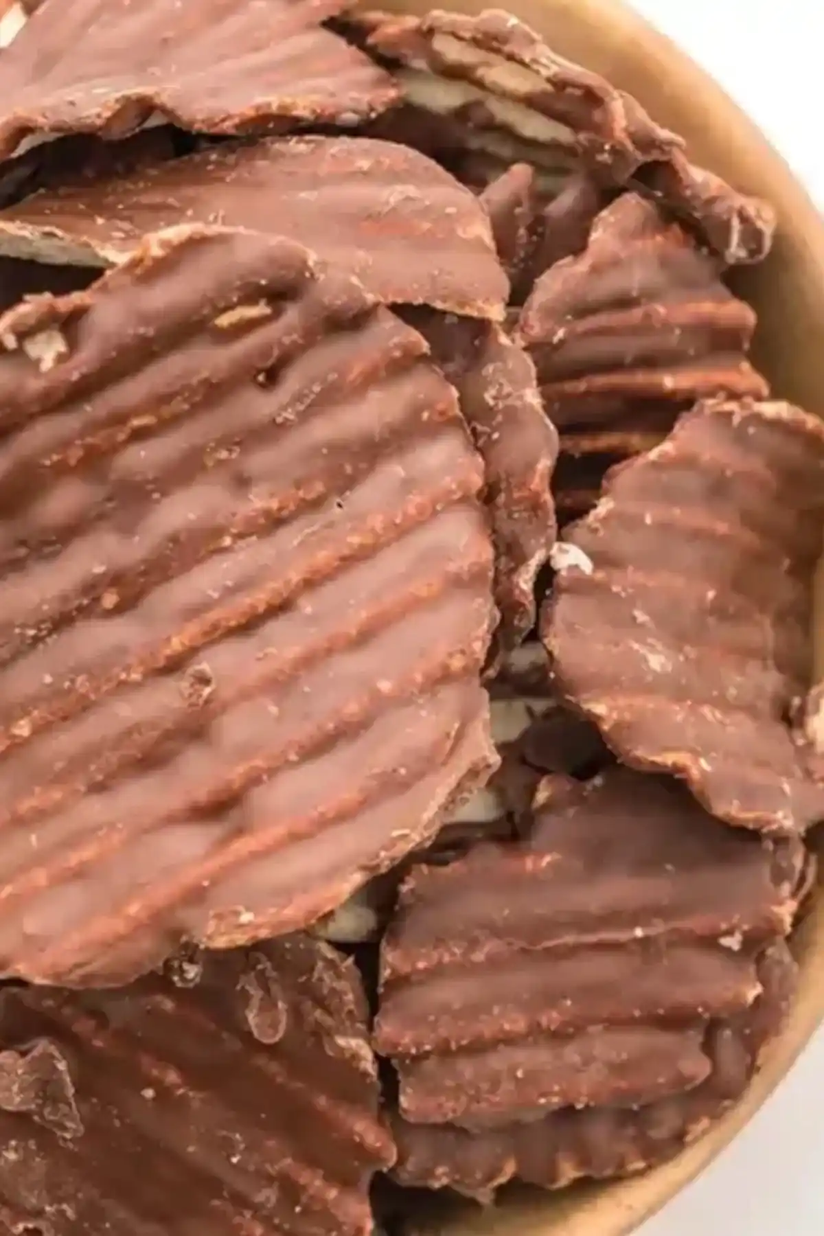 Chocolate Covered Potato Chips Bowl of chocolate-covered potato chips sprinkled with sea salt.